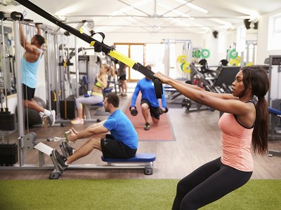 People working out on fitness equipment at a busy gym